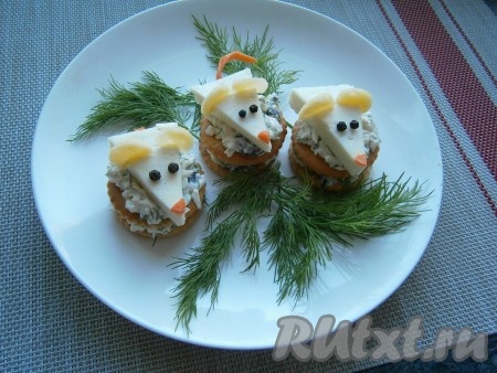 И далее выложить оставшуюся сырную массу. Сверху расположить подготовленных мышек из сыра. Закуску разместить на тарелке, украсить зеленью.
