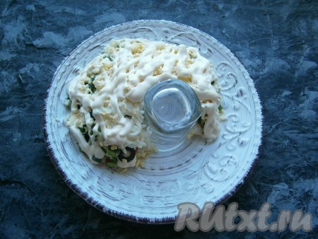 Следующим слоем выложить натёртые на средней тёрке варёные яйца, посолить немного и хорошо смазать майонезом.
