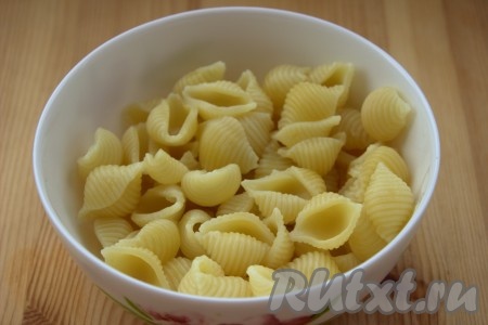 Выложить в кипящую подсоленную воду 80-90 грамм макарон. Отварить макароны в течение 5-6 минут (до полуготовности) с момента закипания воды на небольшом огне, затем откинуть на дуршлаг и дать лишней воде стечь. Для приготовления запеканки потребуется, примерно, 180-200 грамм отваренных до полуготовности макаронных изделий.
