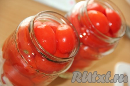 Помидоры вымыть и разрезать на две части в виде лодочки. Получившиеся дольки помидоров выложить плотно разрезом вниз в банки с луком.
