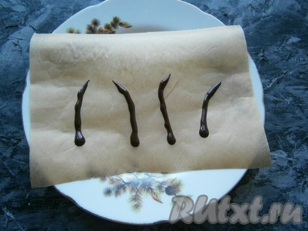 Шоколад растопить на водяной бане, поместить его в кондитерский одноразовый мешок, срезать кончик. На кусок пергамента выдавить шоколад в виде мышиных хвостиков и поместить в холодильник на 10-15 минут.
