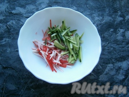 Тонкой соломкой нарезать огурец и крабовые палочки.
