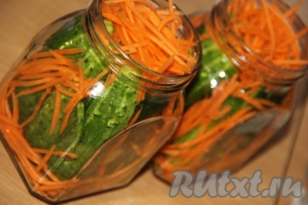 Огурчики вымыть. Очистить морковь и натереть на тёрке для моркови по-корейски. Разрезать каждый огурчик на 4 части в длину. Выложить плотно в банку огурцы и морковь, как на фото.
