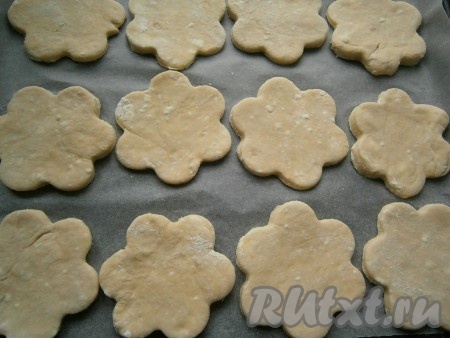 Затем тесто раскатать в пласт толщиной 0,5 см и вырезать коржики формочкой (удобно использовать формочку диаметром 7-8 см), разместить их на противне, застеленном пергаментом. У меня получилось 12 творожных коржиков.
