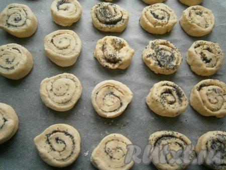 Нарезать рулет на части шириной 1,5-2 см и выложить их срезом вверх на противень, застеленный пергаментом. Песочное печенье с маком увеличится в объёме в процессе выпечки, поэтому выкладывайте заготовки на некотором расстоянии друг от друга.
