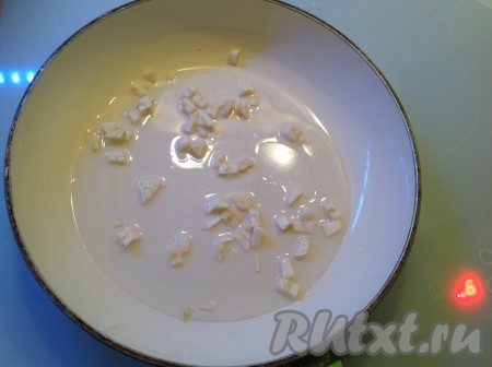 Ставим сковородку на огонь, наливаем немного подсолнечного масла и выкладываем нарезанный чеснок, обжариваем его на небольшом огне, периодически помешивая.
