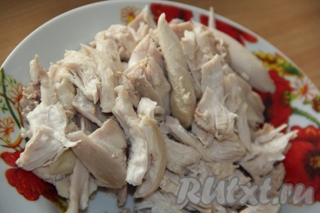 По прошествии времени достать варёное куриное мясо из бульона и отделить от костей. Нарвать мясо на длинные волокна.
