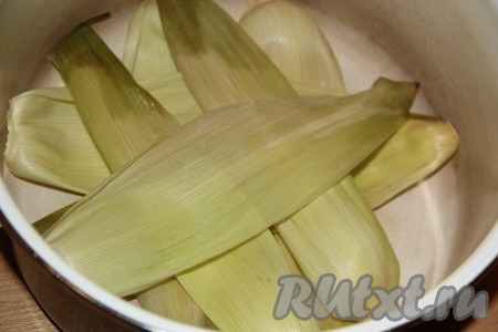 Часть листьев выложить на дно кастрюли. Если нет листьев, можно сварить кукурузу в молоке и без них, но с ними блюдо получается особенно вкусным и ароматным.
