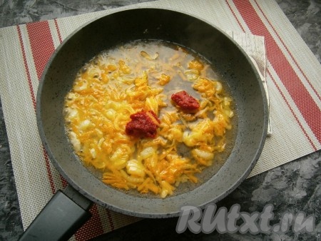 К обжаренным овощам добавить томатную пасту и влить горячую воду (или бульон).
