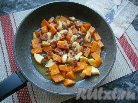 Тушить тыкву с яблоками и сахаром на медленном огне под крышкой минут 10, периодически перемешивая, после чего всыпать оставшийся сахар, добавить лимонный сок, корицу и изюм, перемешать.
