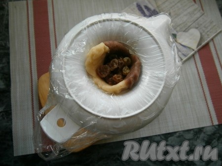 В отверстие из теста поместить по 8-10 ягодок изюма.
