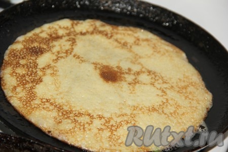 Затем перевернуть и жарить с другой стороны до золотистого цвета. Таким образом пожарить все блинчики.
