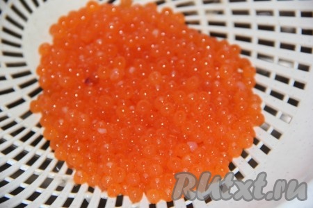 Затем аккуратно слить икру в дуршлаг и дать стечь воде.
