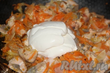 К рыбе, обжаренной с овощами, выложить сметану и перемешать.
