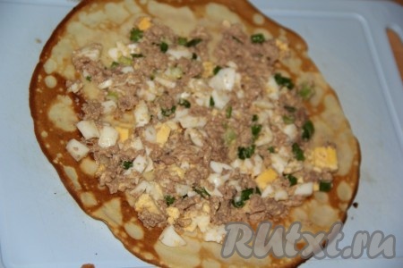 На блин выложить часть начинки и разровнять по все блину, оставляя чистыми края.
