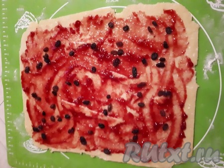 Смазать пласт теста джемом (у меня желе из чёрной смородины) и посыпать изюмом.
