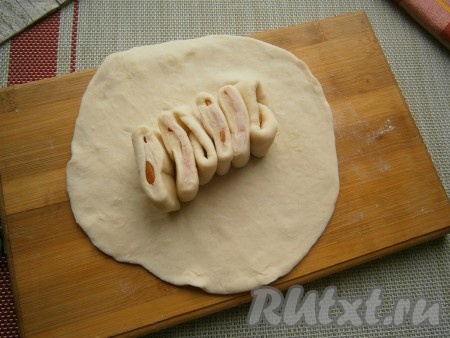В середину предварительно раскатанной лепёшки диаметром 13-14 см расположить 6 кусочков теста с ветчиной, стоящих на ребре.
