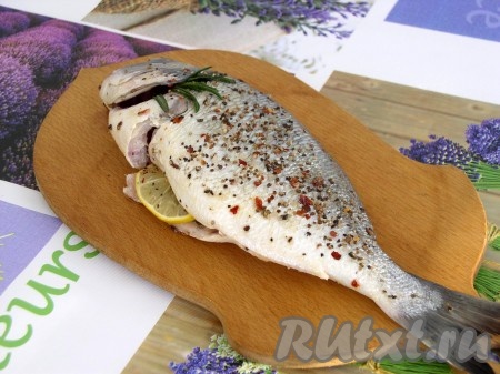 Рыбку натереть специями, полить маринадом внутри и снаружи, оставить на 10-15 минут.