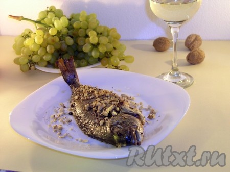 Запекаем дорадо в разогретой духовке при температуре 150-160 градусов до золотистой корочки. Проверять можно с 20-й минуты (проткнуть рыбку деревянной шпажкой, если выделяется сок прозрачный - значит рыба готова). Смазать лёгким слоем сметаны, используя кисточку. Посыпать толчёными орехами и подсушить в духовке ещё 5 минут. Дорадо, запечённая с розмарином и перцем, готова. Подавать с сухим белым вином, можно с белым виноградом, орехами.
