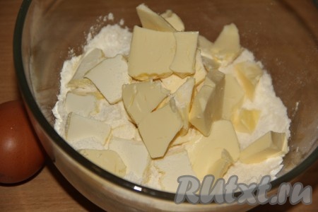 Для приготовления песочного коржа соединить просеянную муку, разрыхлитель и сахар, добавить кусочки холодного сливочного масла.
