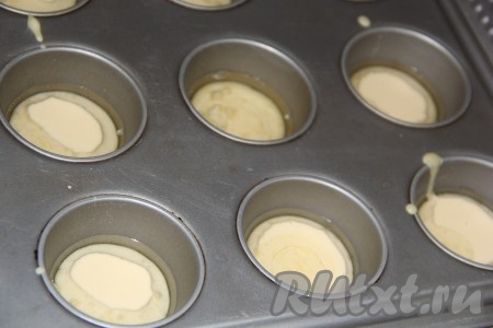 Достать форму из духовки и разлить тесто по лункам, заполняя их на 1/2 объёма. Для удобства я перелила тесто в мерный стакан с носиком.&nbsp;
