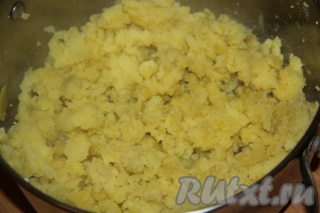 Варёный картофель размять толкушкой и выложить в кастрюлю.
