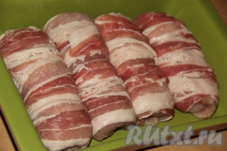 Выложить подготовленные куриные рулетики в беконе в жаропрочную форму и поставить в разогретую духовку.
