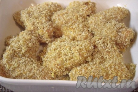 Противень (или жаропрочную форму) слегка смазать растительным маслом. Выложить запанированные куриные крылья и отправить запекаться в заранее разогретую до 180 градусов духовку на 35-40 минут (до зарумянивания).