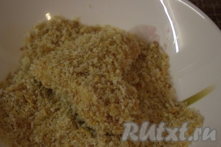 Затем куриные крылышки хорошо обвалять со всех сторон в панировочных сухарях.