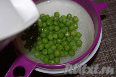 Замороженный горошек поместить в сито, обдать кипятком (если используете консервированный горошек, необходимо предварительно слить жидкость).
