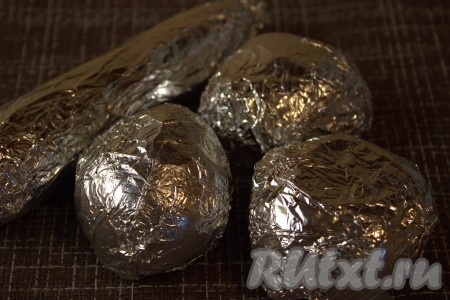 Картофель, свеклу и морковь тщательно вымыть при помощи щётки (или жёсткой стороной губки для мытья посуды), затем обсушить при помощи бумажного полотенца. Каждый овощ (по отдельности) завернуть в фольгу, поместить на&nbsp;противень и поставить запекаться в разогретую духовку при температуре 180 градусов. Картофель и морковь будут запекаться минут 40, а свекла - 60-80 минут. Время запекания овощей зависит от размера. Готовность можно проверить, проткнув овощи зубочисткой (если овощ легко прокалывается - значит готов).