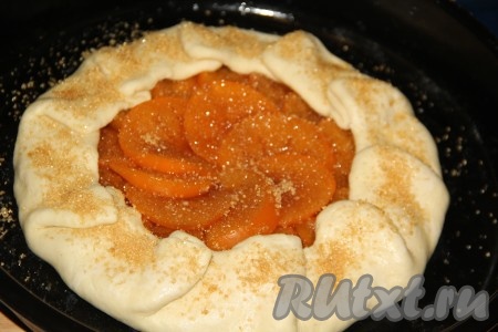 Присыпать тесто сахаром и поставить противень с пирогом с хурмой в разогретую духовку.
