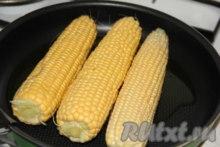 Поставить сковороду на огонь и выложить кукурузу.
