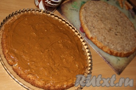 Выложить всё сгущённое молоко на одну половинку коржа и равномерно распределить.
