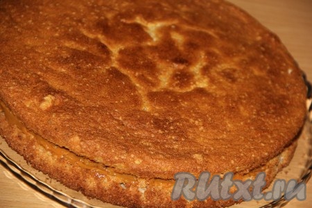 Накрыть начинку второй половиной коржа и слегка прижать. Поставить торт с орехами и варёной сгущёнкой в холодильник на ночь.
