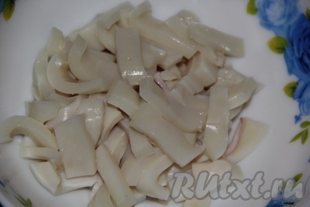 Нарезать остывшие кальмары на полоски.
