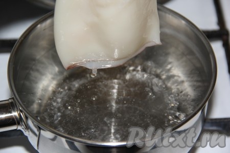 В кастрюлю влить воду и довести до кипения. Как только вода сильно закипит, опустить в неё тушку кальмара.&nbsp;
