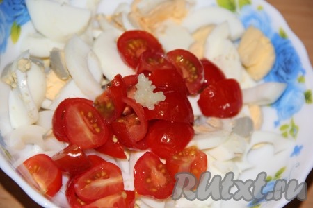 Яйца предварительно сварить (варить минут 10 с момента закипания воды), затем остудить, очистить и нарезать на средние кубики. Соединить нарезанные яйца, кальмары и помидоры.
