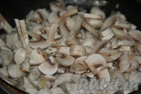 Шампиньоны промыть водой, крупные грибы разрезать на 2-4 части, а затем нарезать на достаточно тонкие пластинки и выложить в сковороду к курице и луку, обжаривать минут 10, помешивая время от времени.
