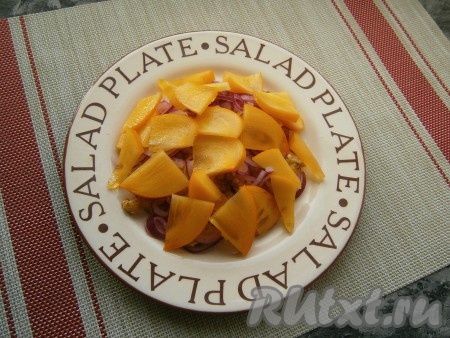 Далее распределить оставшийся маринованный лук и сверху выложить нарезанную хурму.
