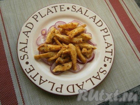 На плоскую тарелку выложить половину отжатого маринованного лука, сверху разложить кусочки остывшего куриного филе.
