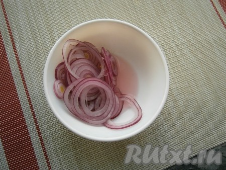 Очистить лук, нарезать тонкими колечками, влить уксус, перемешать и оставить минут на 15.
