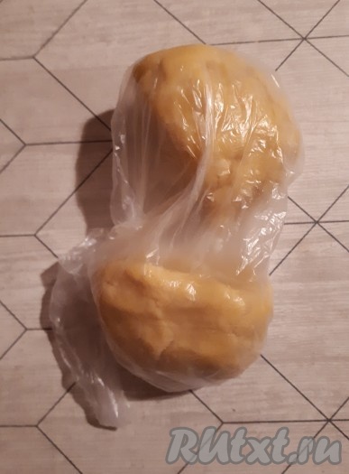 Разделить мягкое, приятное в работе песочное тесто на 2 равные части, завернуть в пакет и убрать в холодильник минимум на полчаса.
