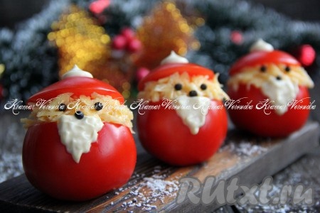 Накрыть верх начинки шапочкой (отрезанной крышечкой от помидора). Из горошин чёрного перца сделать глазки и носик. В треугольник, вырезанный на стенке каждого фаршированного помидора, аккуратно выложить немного майонеза, имитируя бороду. Очень вкусную, аппетитную новогоднюю закуску "Дед Мороз" можно подавать к столу.