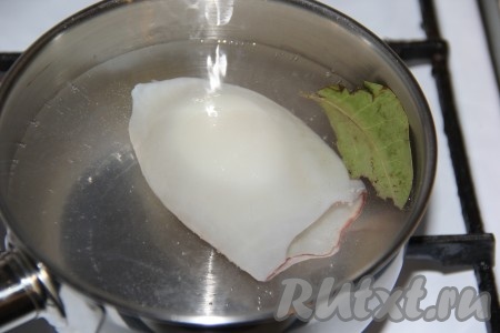 Влить в кастрюлю воду, по желанию, можно добавить лавровый листик и отправить на огонь. В хорошо закипевшую воду выложить тушку кальмара (я обычно отвариваю по 1-2 тушке) и варить секунд 10. Затем достать кальмара из кастрюли, выложить на тарелку. Снова воде в кастрюле дать хорошо закипеть, опустить следующую тушку и тоже варить 10 секунд. Таким образом отварить всех кальмаров.
