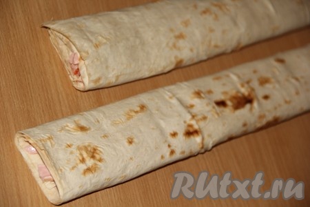 Завернуть начинку в лаваш так, чтобы получился плоский рулет шириной, примерно, 5-6 см. У нас получатся два рулета.
