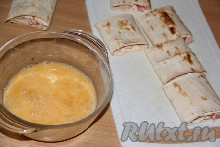Нарезать каждый рулет на кусочки шириной 6х6 см. Для приготовления кляра в тарелку вбить яйца, всыпать соль, слегка взбить.&nbsp;
