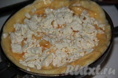 Как только на поверхности практически не останется сырого яйца, выложить творог поверх яичницы.
