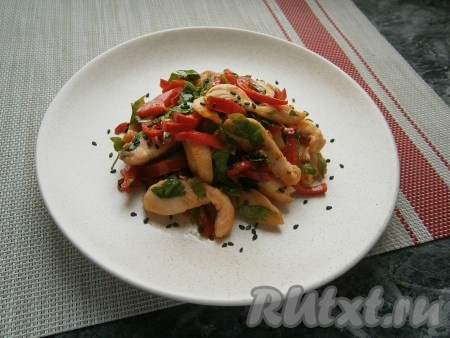 Выложить салат из курицы и перца на плоскую тарелку горкой, посыпать чёрным кунжутом.
