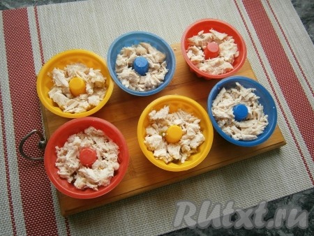 Затем выложить куриное филе, не доходя до верха формочек около 1 см.
